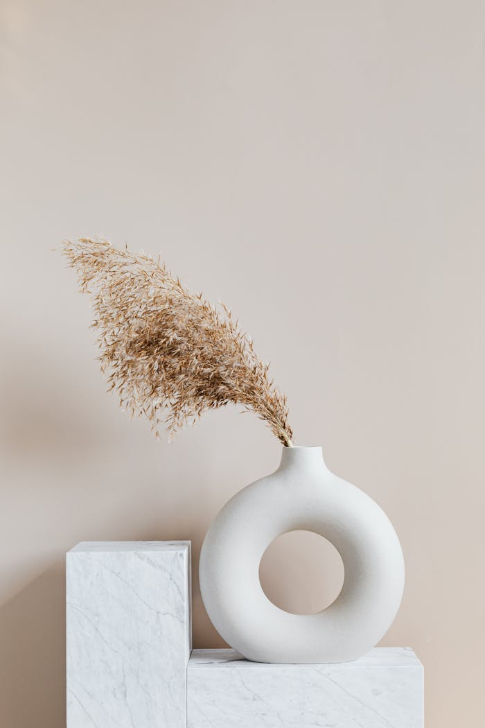 Crafting Captivating Headlines: Your awesome post title goes here Elegant ceramic vase with dried grass on a marble pedestal, showcasing simplicity and minimalism.